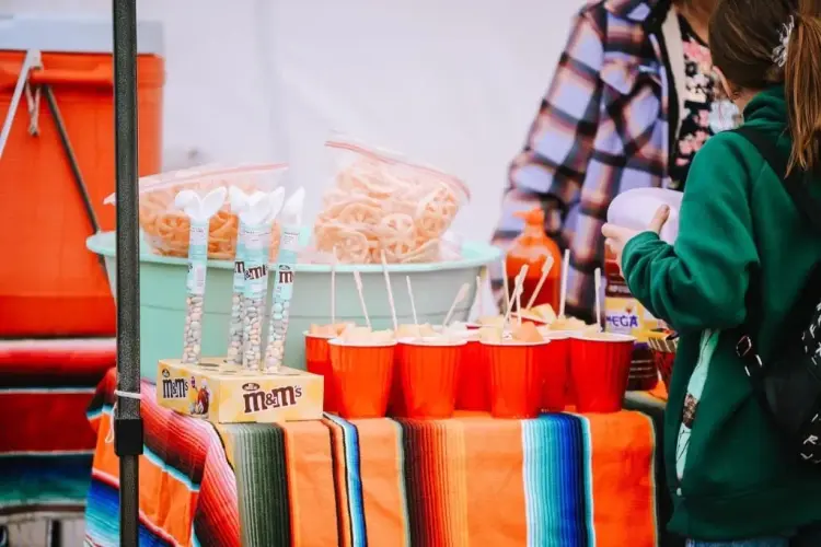 Display of chicharones and candy with a girl on the side purchasing.